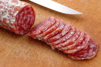 Des tranches de saucisson posées sur une planche de bois
