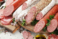 Toutes sortes de saucissons posées sur une planche