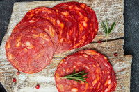 Des tranches de chorizo posées sur une planche de bois