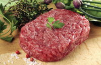 Un steak haché façon bouchère sur une planche de bois