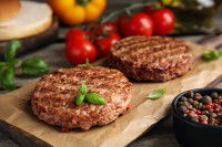 Deux steaks hachés cuits sur une planche de bois