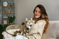 Une femme fait un câlin à son chat dans le salon