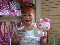 Yuko Yamaguchi portant dans les mains une peluche et une figurine d'un personnage de Sanrio