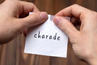 Une femme tient un papier avec écrit le mot « charade »