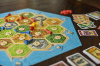 Plateau du jeu  « Les Colons de Catane » et ses pions posés sur une table