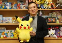 Satoshi Tajiri tenant une peluche Pikachu