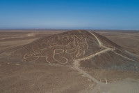 Photo d'une colline dans le désert de Nazca au Pérou où est dessiné un très grand chat.