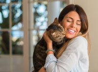Une femme fait un câlin à un chat