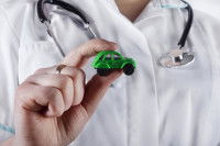 Un vétérinaire tenant une petite voiture verte dans sa main