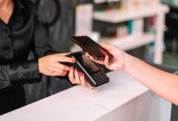 Une femme paye le toiletteur avec son téléphone