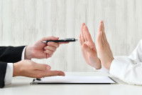Une personne proposant à une autre de signer un papier, cette dernière signalant son refus