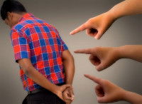 Une personne de dos pointée du doigt par trois autres personnes