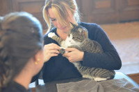 Une femme tenant un chat dans ses bras sous le regard d'une autre femme