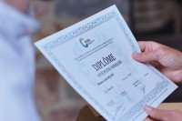 Une personne tenant un diplôme d'ostéopathe animalier