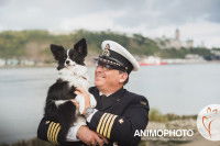 Un marin pose avec son chien dans les bras