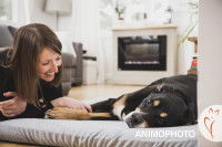 Une femme pose avec son chien allongé