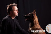 Un homme pose en studio avec son chien