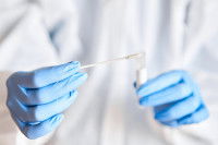 Un laborantin fait un test salivaire