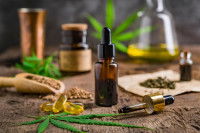 De l'huile de CBD et du cannabis sur une table en bois