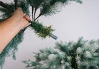 Un homme assemble un faux sapin de Noël