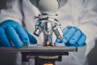 Un laborantin observe un échantillon au microscope