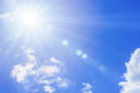 Le soleil et ses rayons dans un ciel bleu