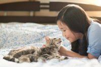 Une jeune femme prend soin de son chat