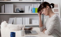 Une femme fatiguée devant son ordinateur