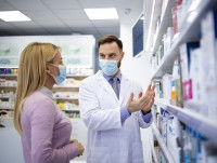 Un pharmacien conseille une femme sur les médicaments à acheter