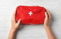 Une femme tient une trousse de secours dans ses mains