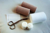 Des pansements, bandages et ciseaux sur un fond gris