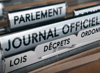 Un classeur rempli de documents juridiques triés par lois, décrets et publications au journal officiel