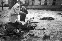 Photo en noir et blanc de deux femmes marchant dans une rue de Leningrad pendant le siège de 1941-1944