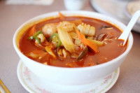 Un ragoût « lóng hu fèng » dans un bol blanc posé sur une table