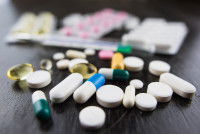 Divers médicaments en gélules et comprimés posés sur une table
