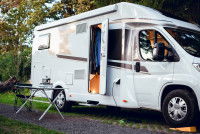 Un camping-car avec la porte ouverte dans un champ