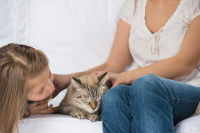 Une maitresse et sa fille caressent leur chat