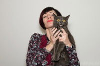 Une maitresse tenant son chat gris dans ses bras