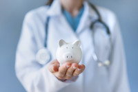 Une vétérinaire tient une petite tirelire dans la main