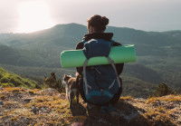 Un randonneur regarde le coucher de soleil avec son chat