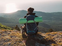 Un randonneur en montagne assis à côté de son chat