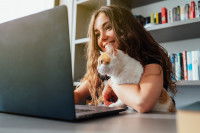 Une femme avec son chat sur son ordinateur