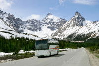 Un car blanc traversant les montagnes par la route