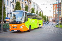 Un car vert et orange roulant en ville